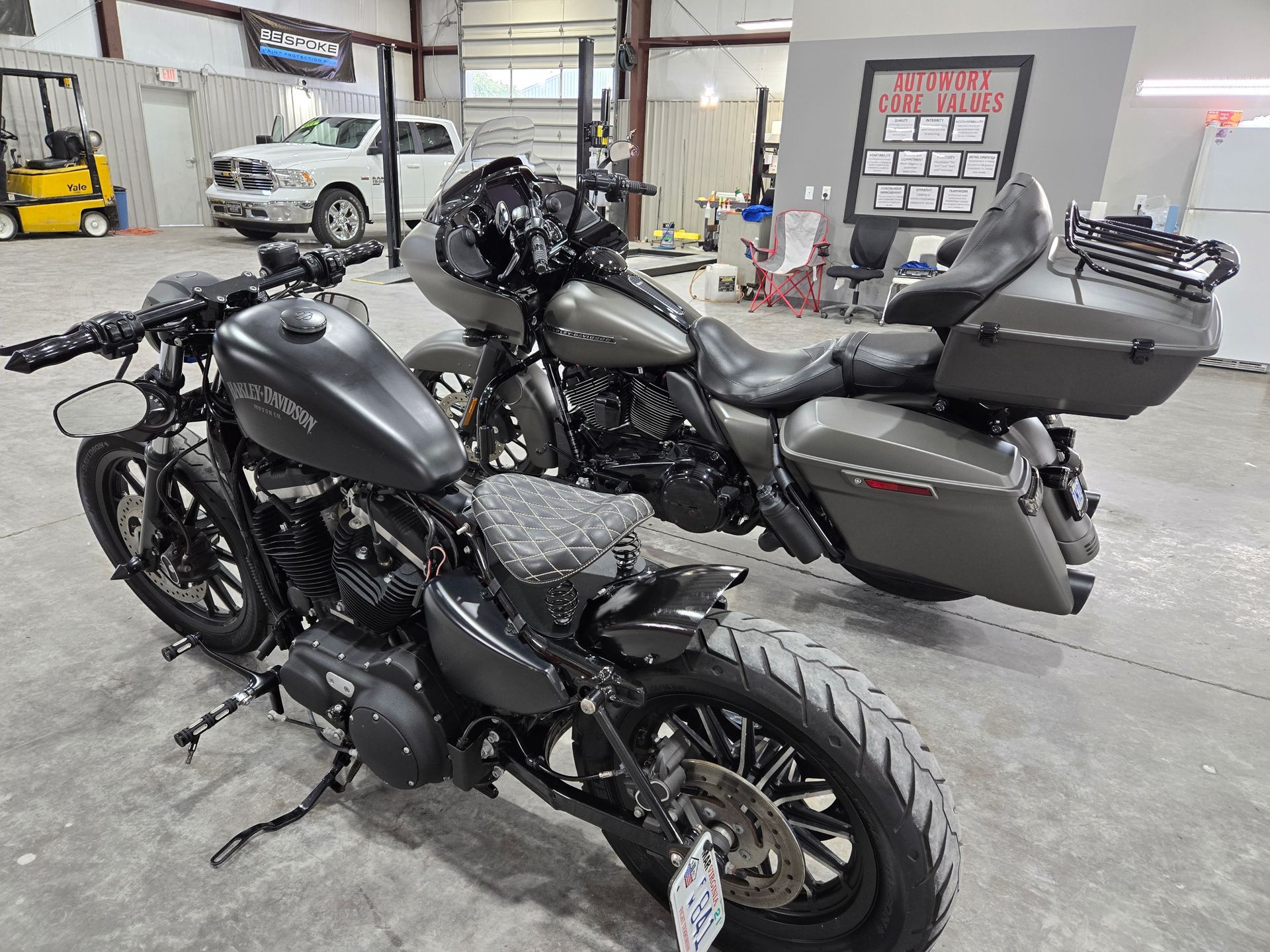 Two motorcycles are parked next to each other in a garage.