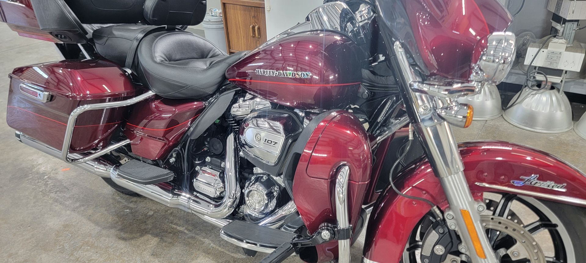 A red harley davidson motorcycle is parked in a garage.
