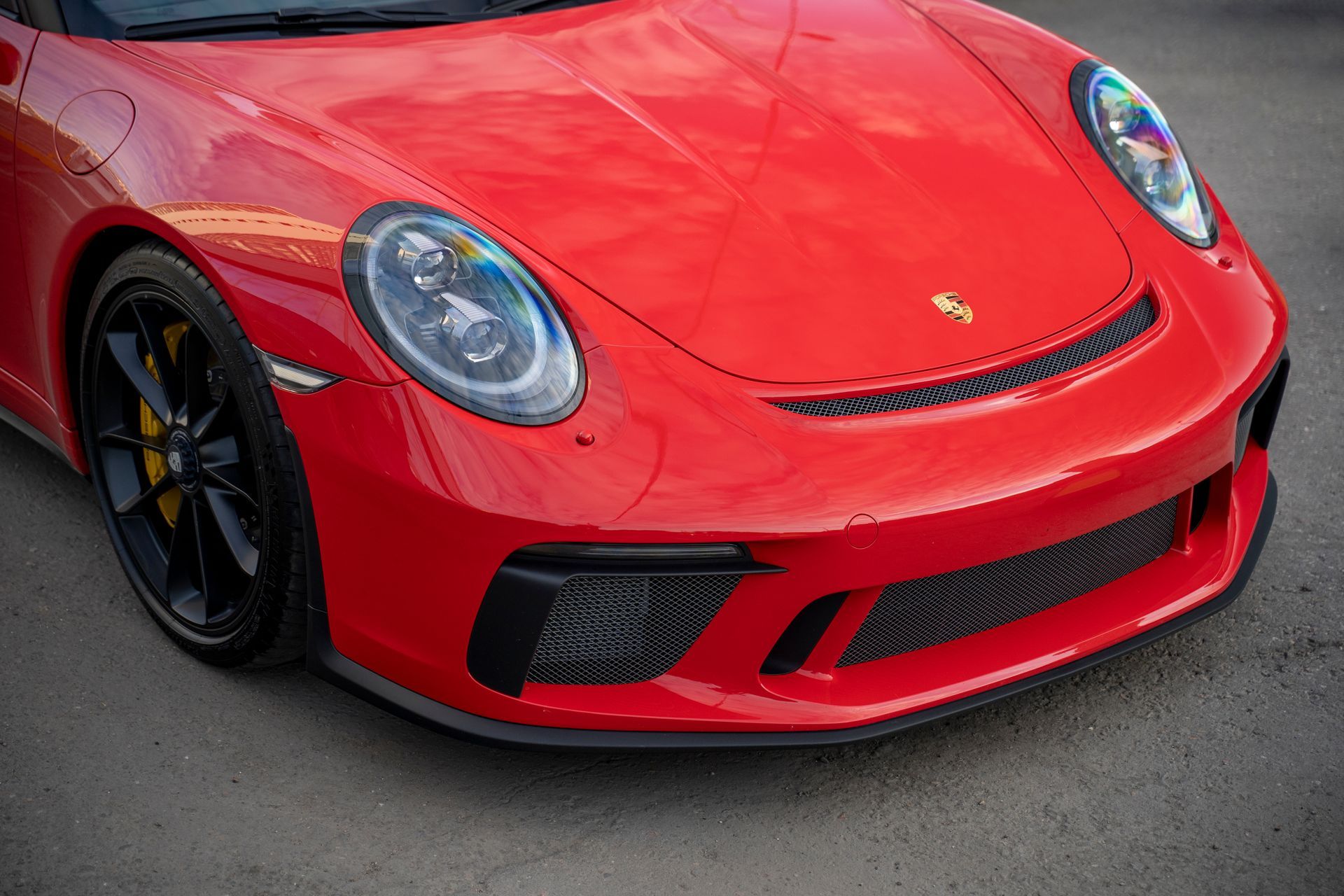 A red porsche 911 gt3 rs is parked on the street.