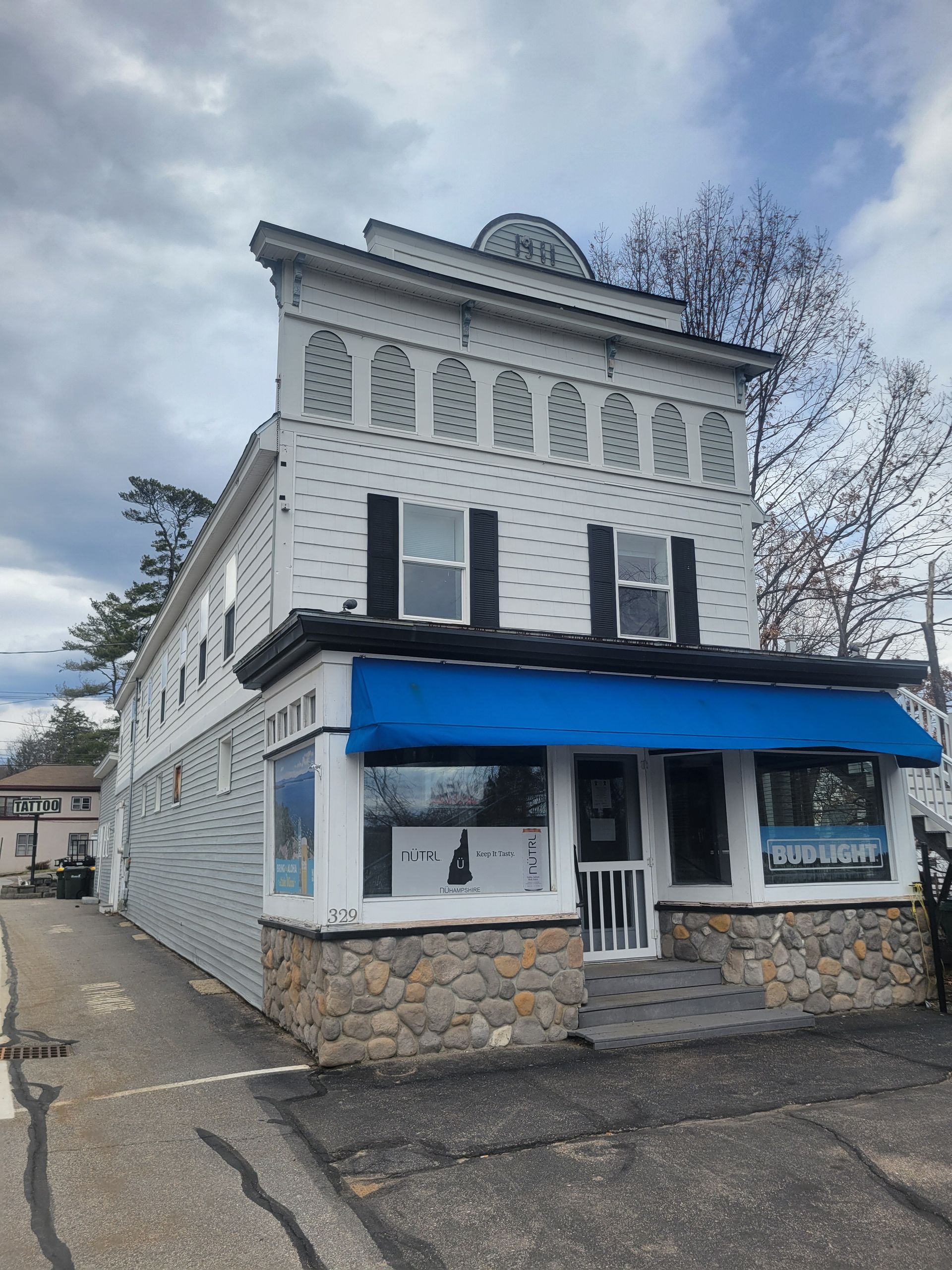 A white building with a blue awning on it