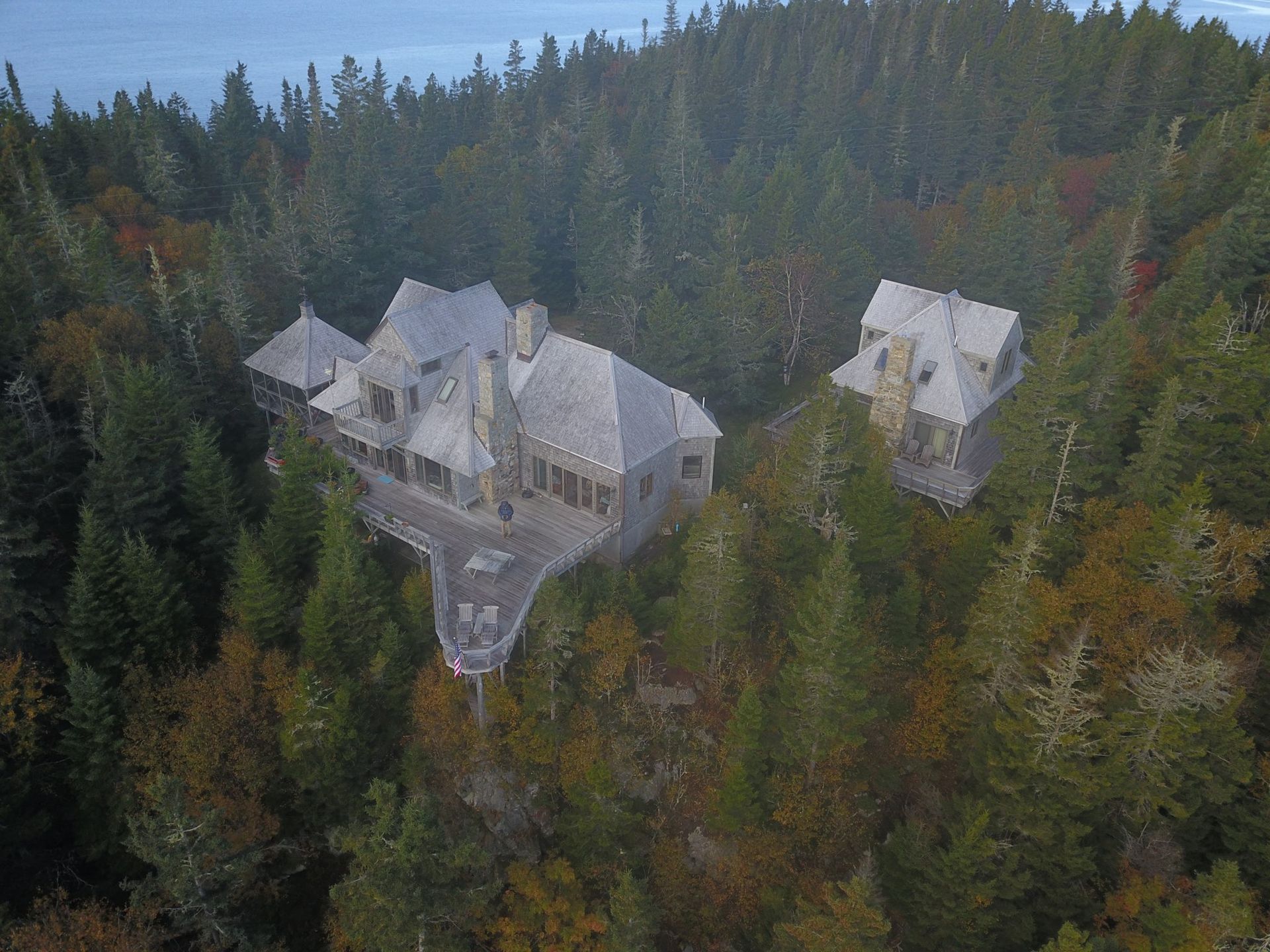An aerial view of a house in the middle of a forest