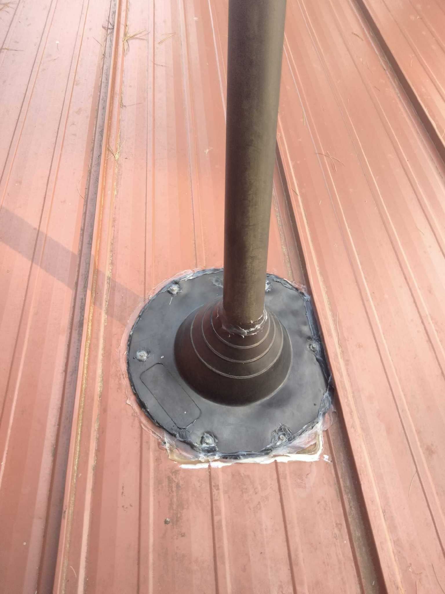A pipe is sitting on top of a wooden roof.