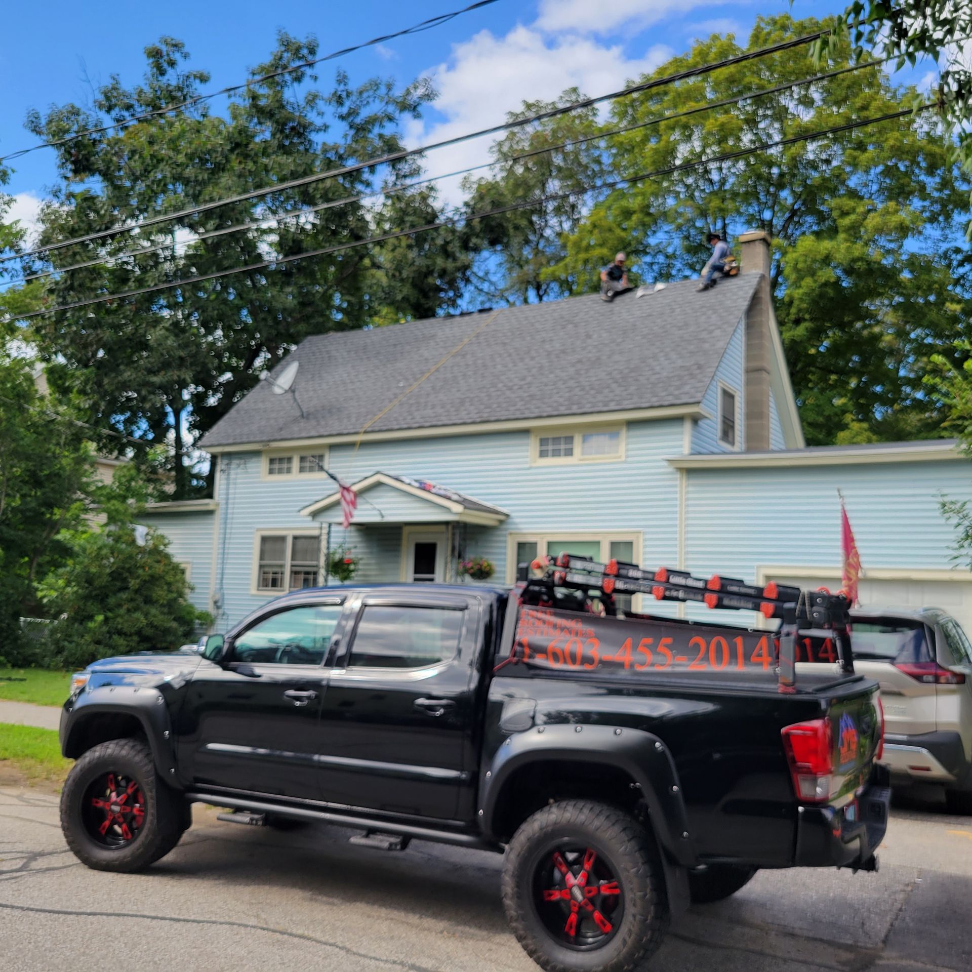 A black truck is parked in front of a house
