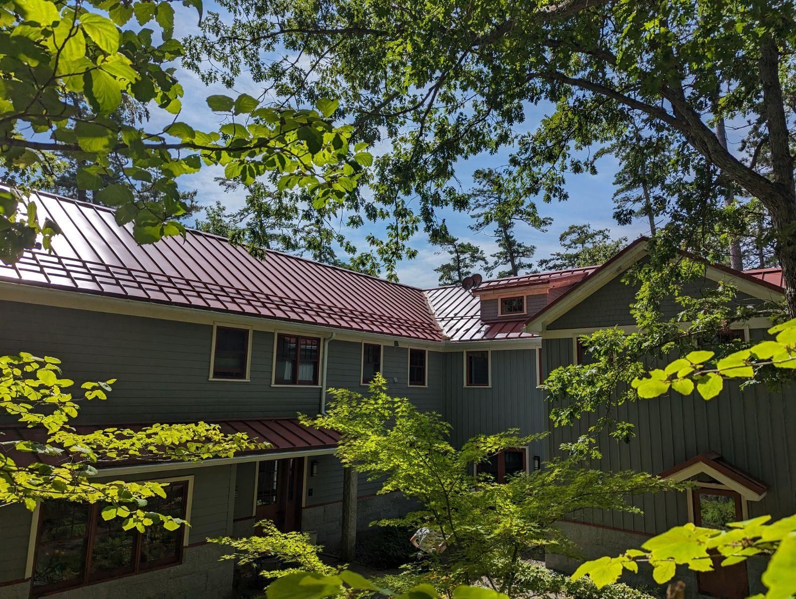 A house with a red roof is surrounded by trees