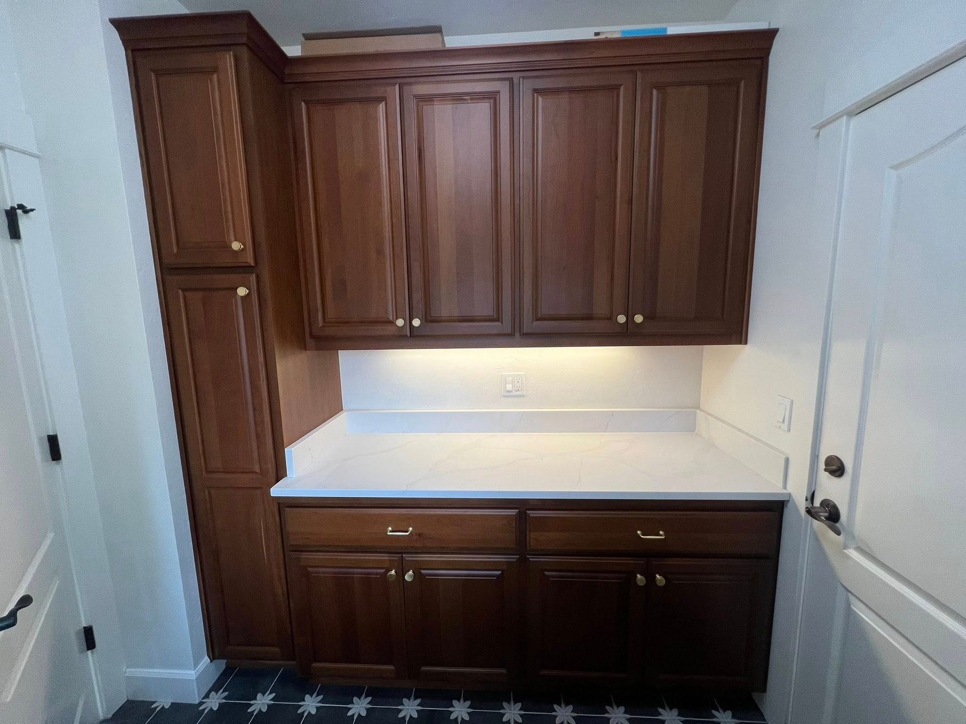 Living room with fireplace, tan leather sofa, blue chairs, and large windows.