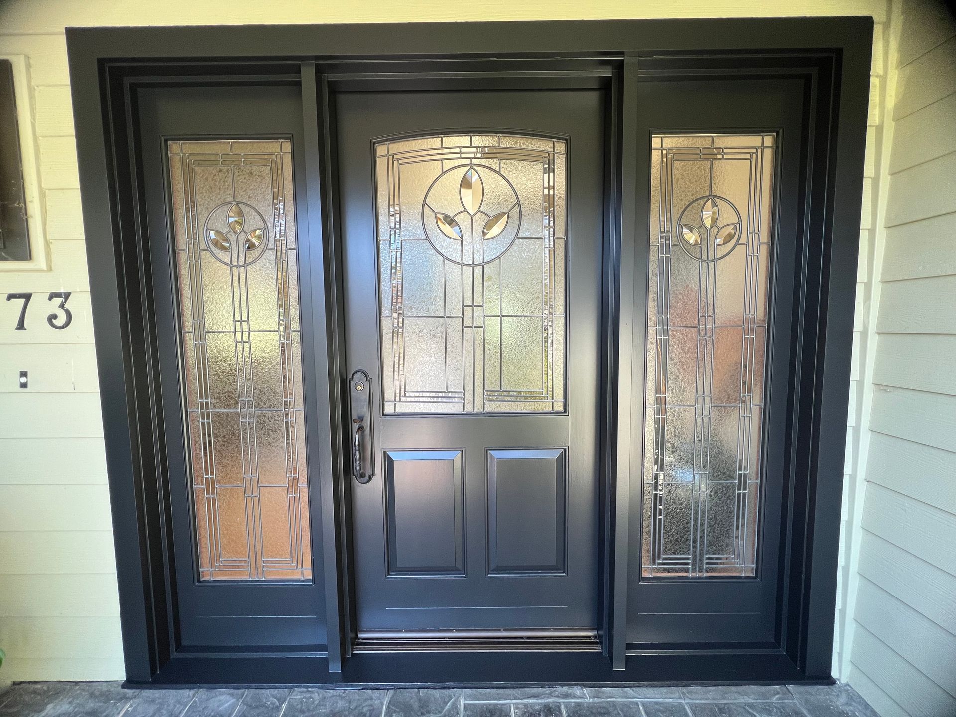 Black front door with decorative glass panes.