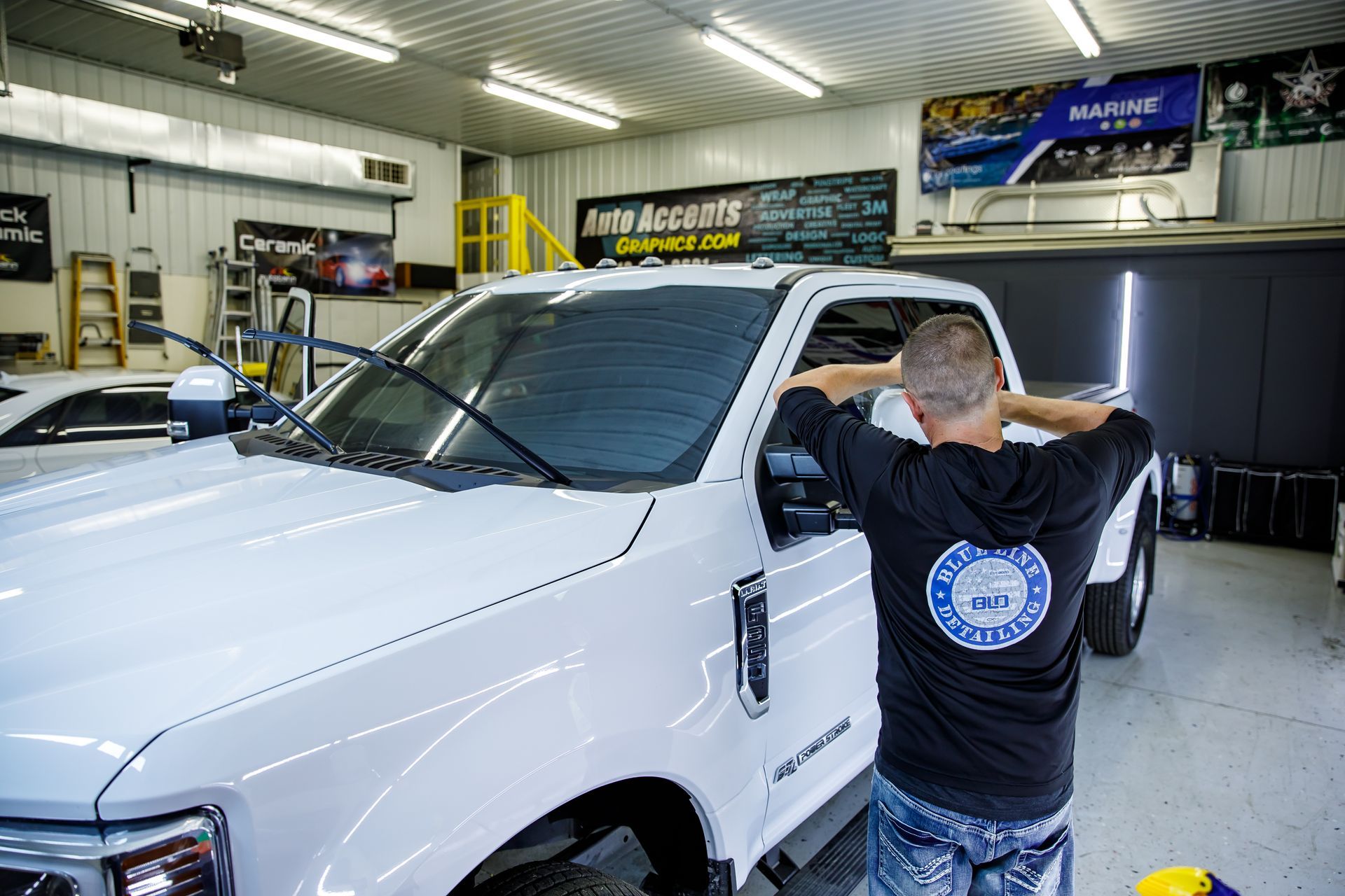 A person is applying protective film to the hood of a car.