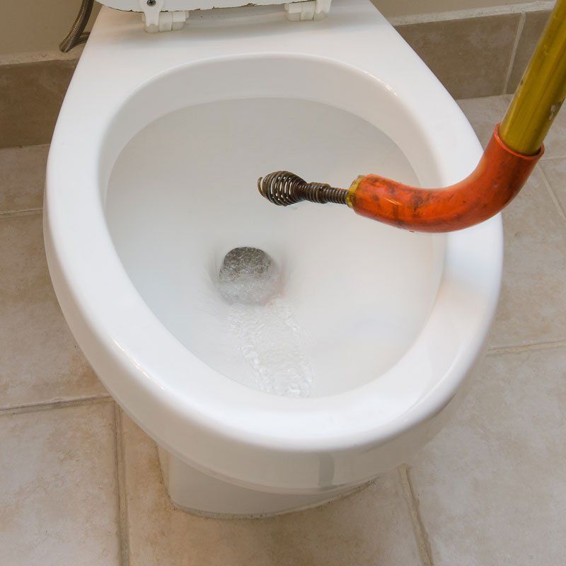 Plumber's Snake Unclogging a Toilet — Ericson's Remodeling & Drain Cleaning, LLC
