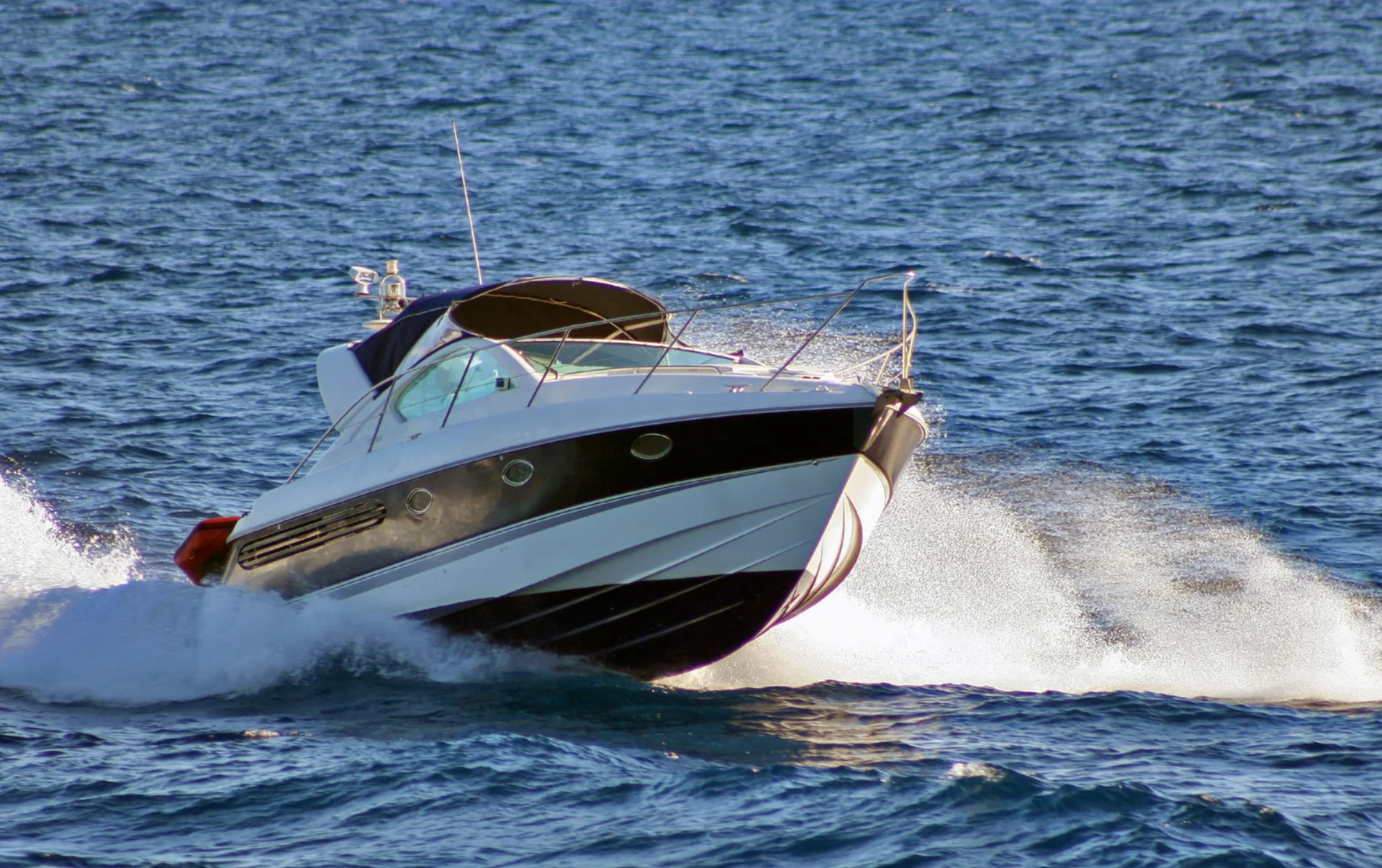 A white and black boat is floating on top of a body of water.