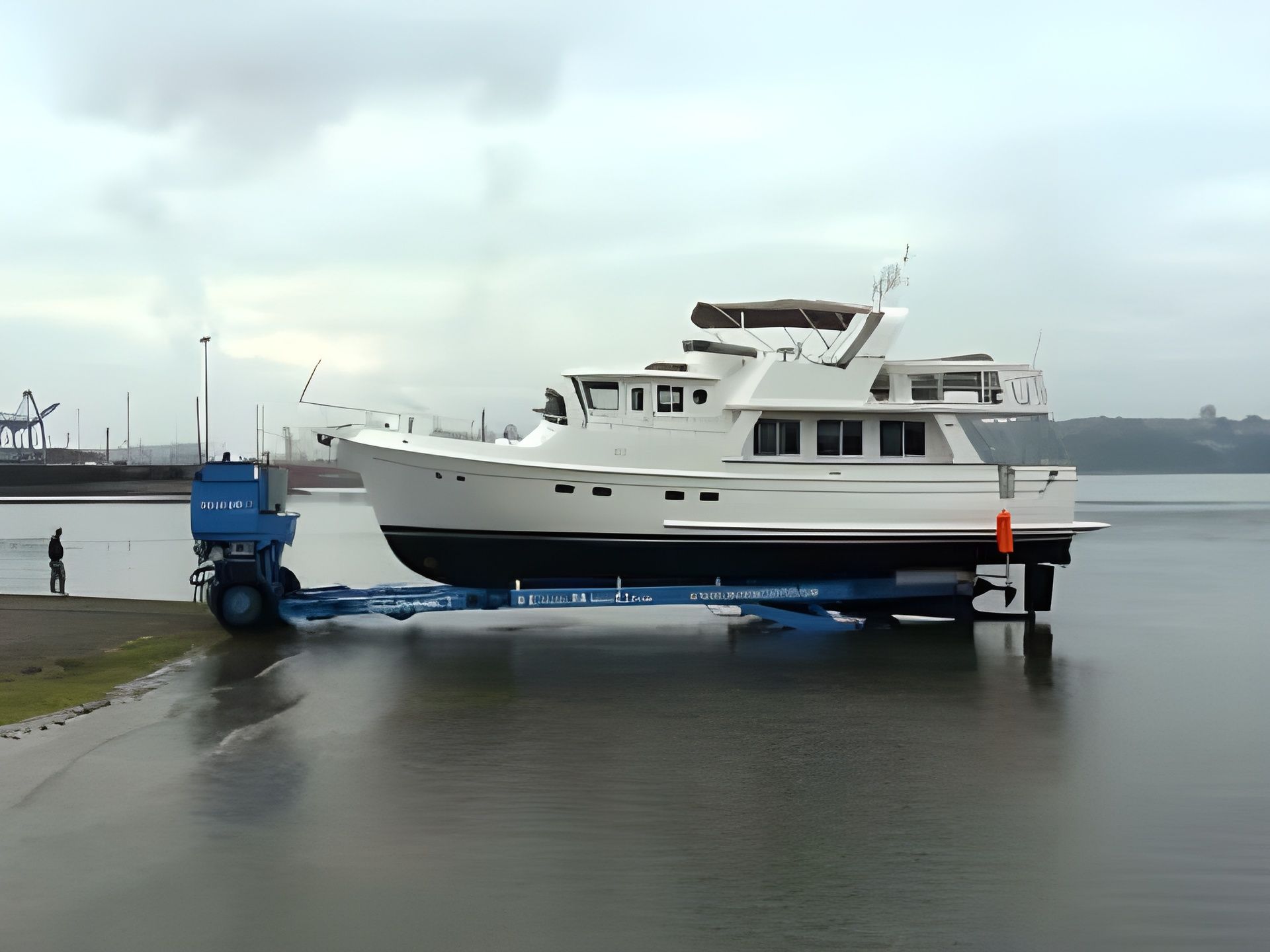A boat is being towed by a trailer in the water