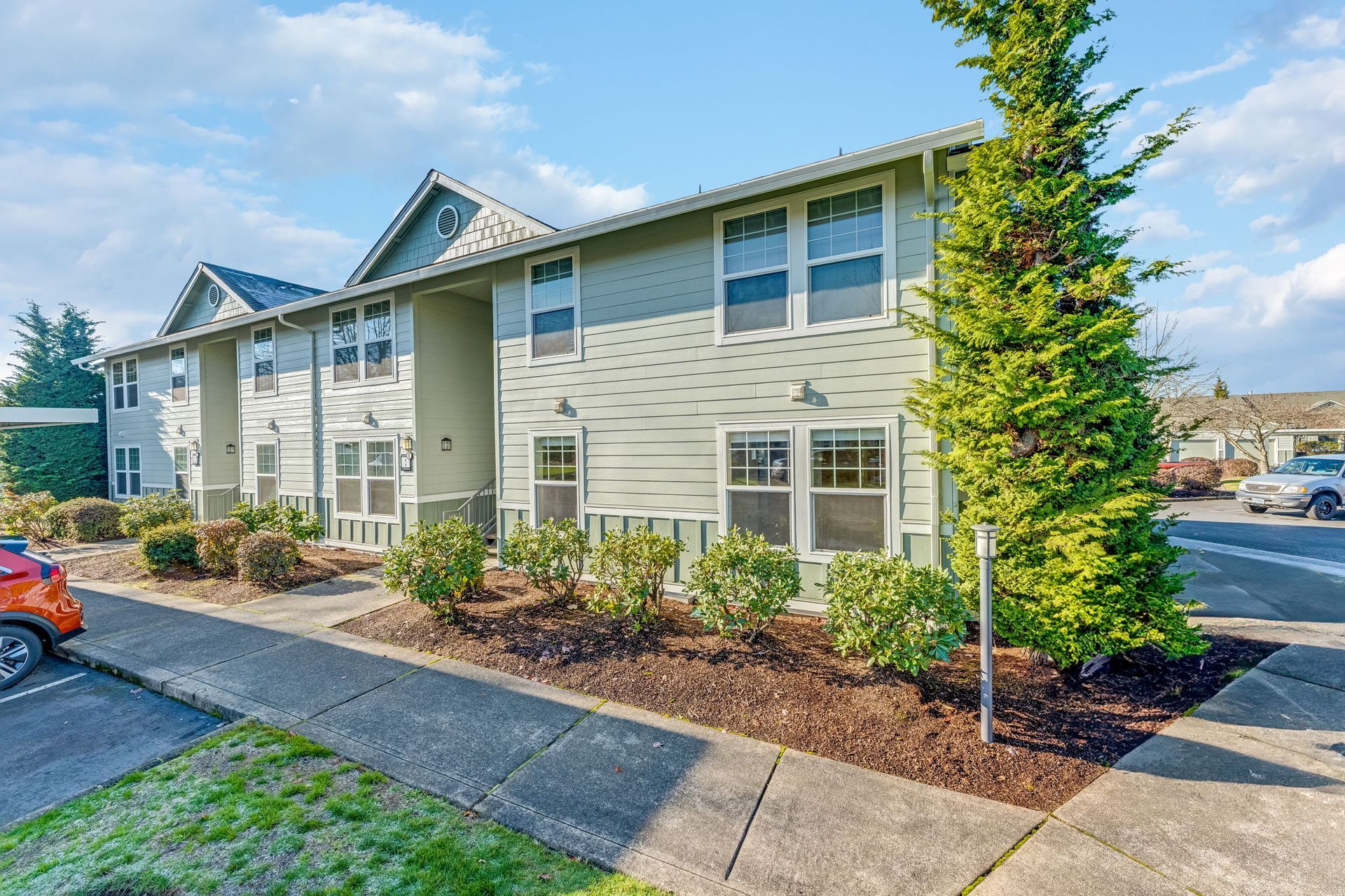 Front of apartment building with sidewalk lining the perimeter.
