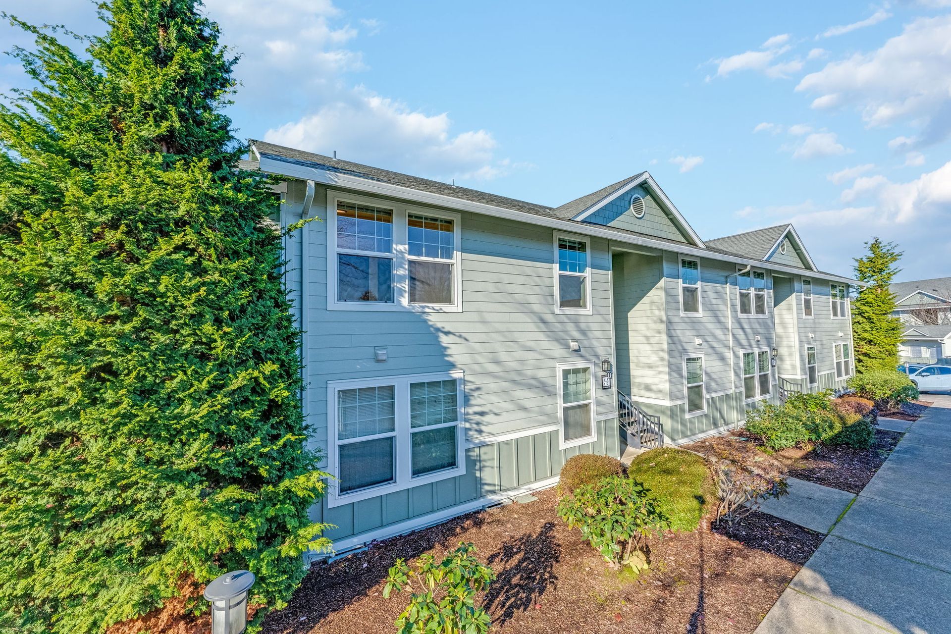 Front of apartment building with landscaping.