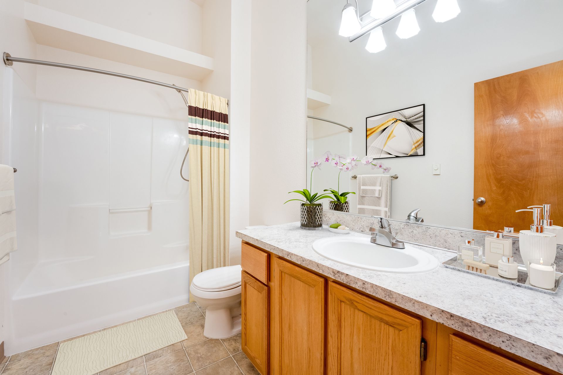 Bathroom with ample counter space and curved shower bar covering shower/tub.