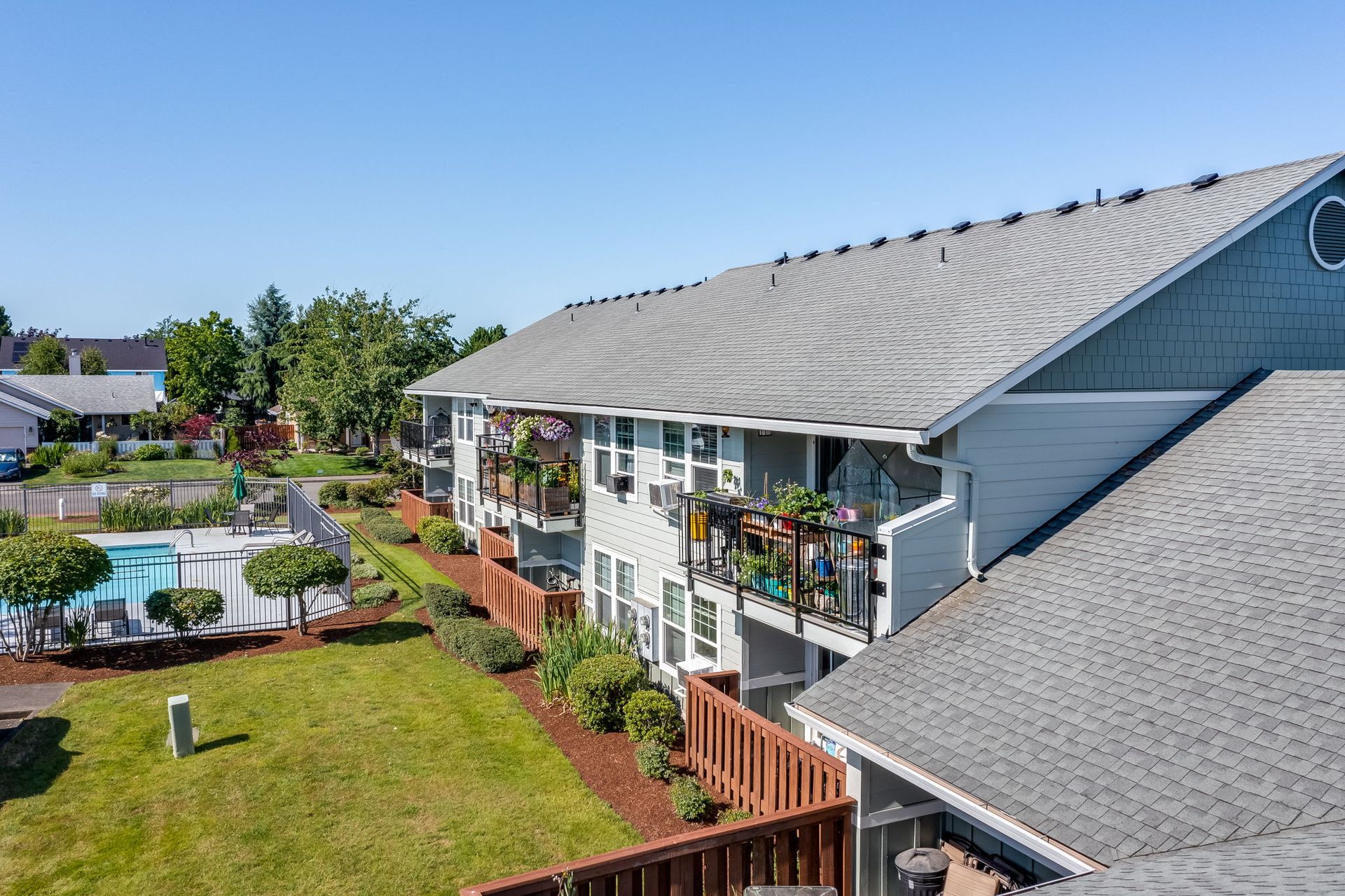 Back of building featuring private balconies and back patios over looking pool.