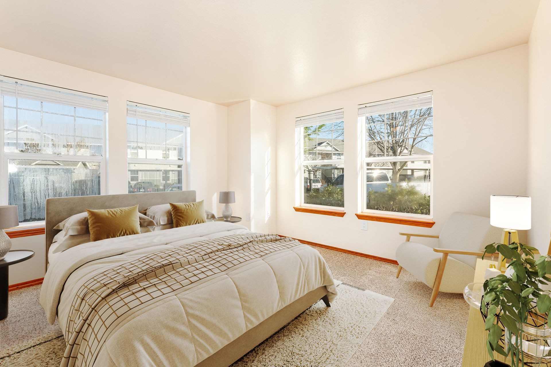 Large corner bedroom with two walls of windows letting in plenty of light.