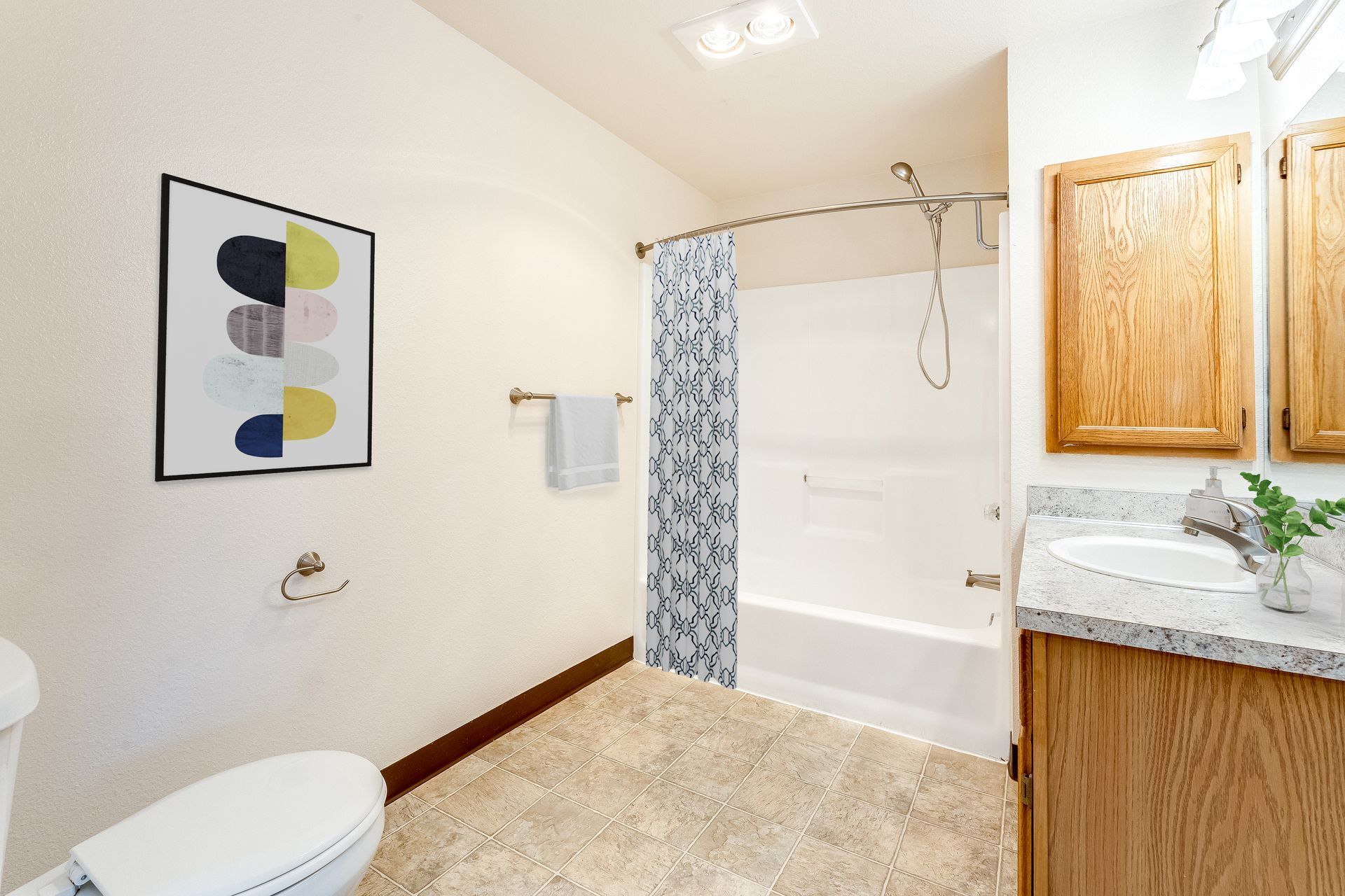 Large bathroom with curved shower bar and plenty of floor space to move around.