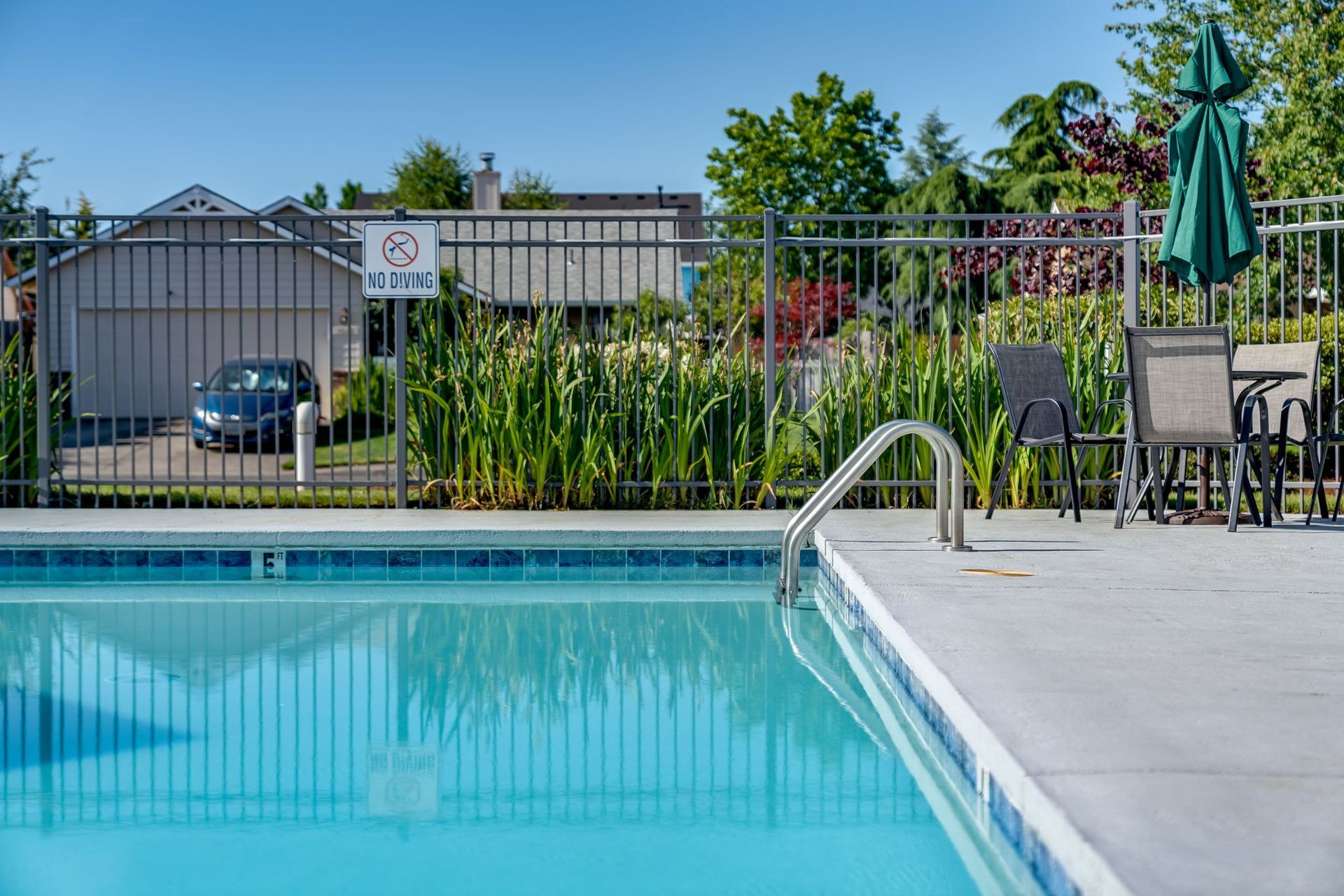 View of swimming pool w/steps leading down into water.