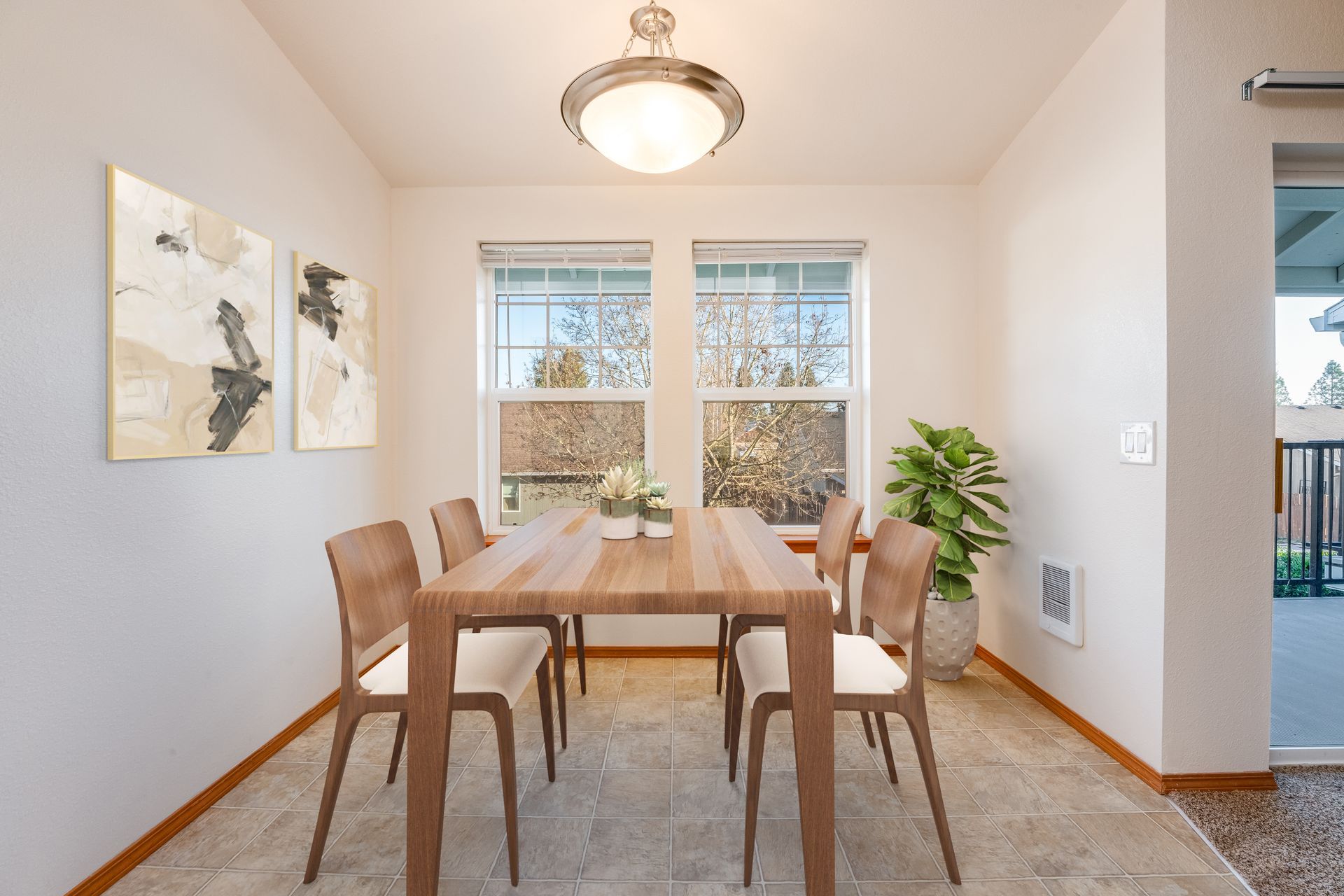 Dining room with two large windows on end wall and hanging light fixture.