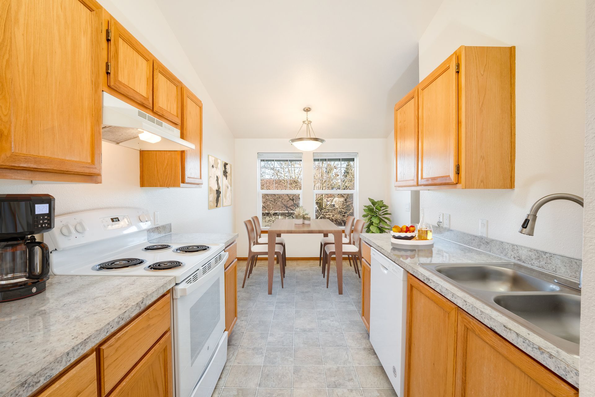 View of galley style kitchen with dining room in the background.