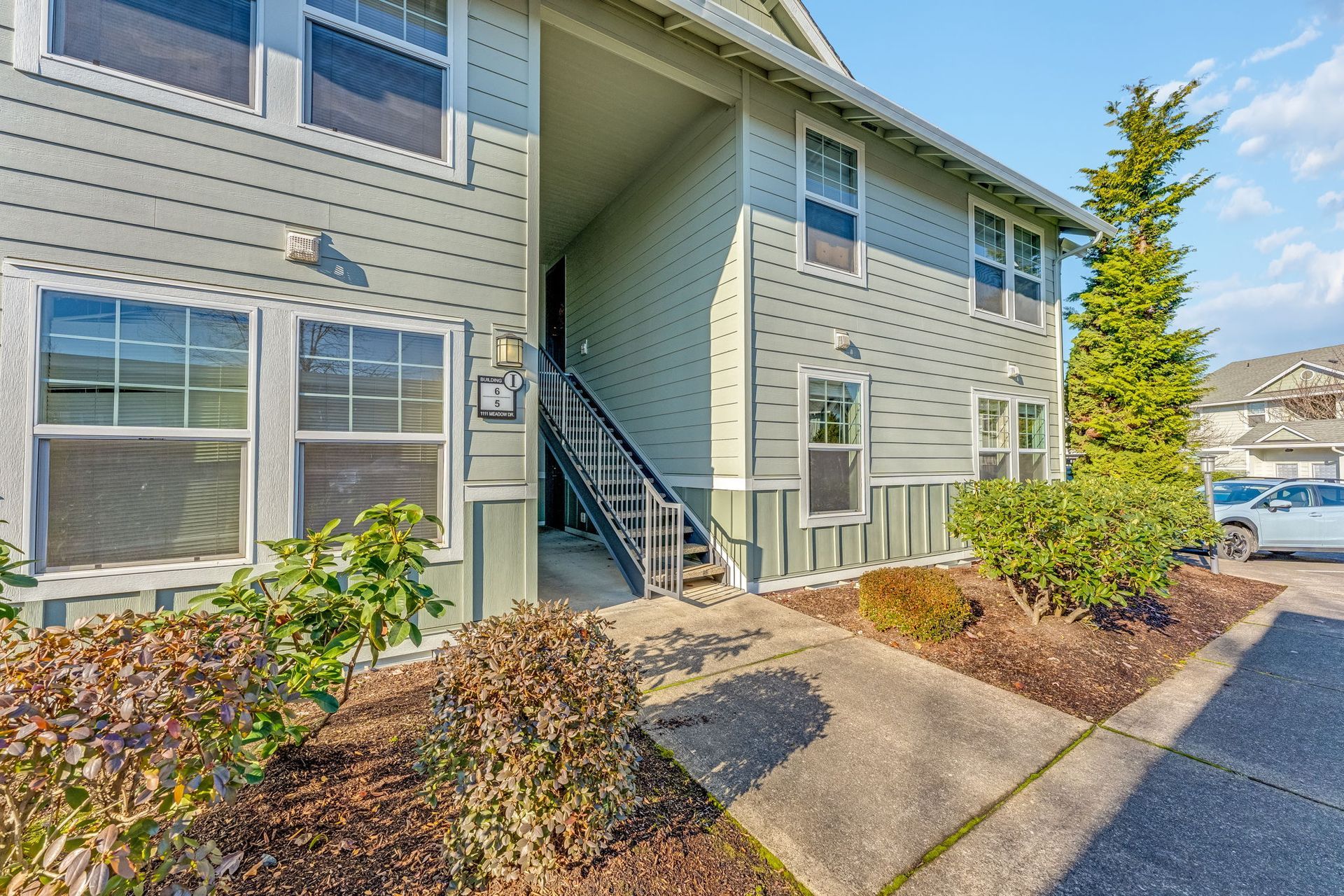 Front of apartment building with sideview of entryway.