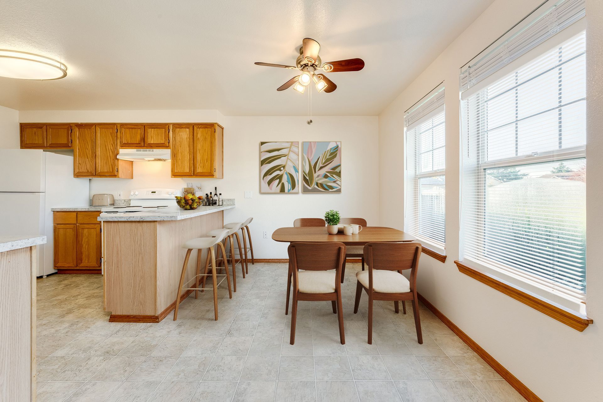 Dining room with two large windows and breakfast bar off kitchen counter.