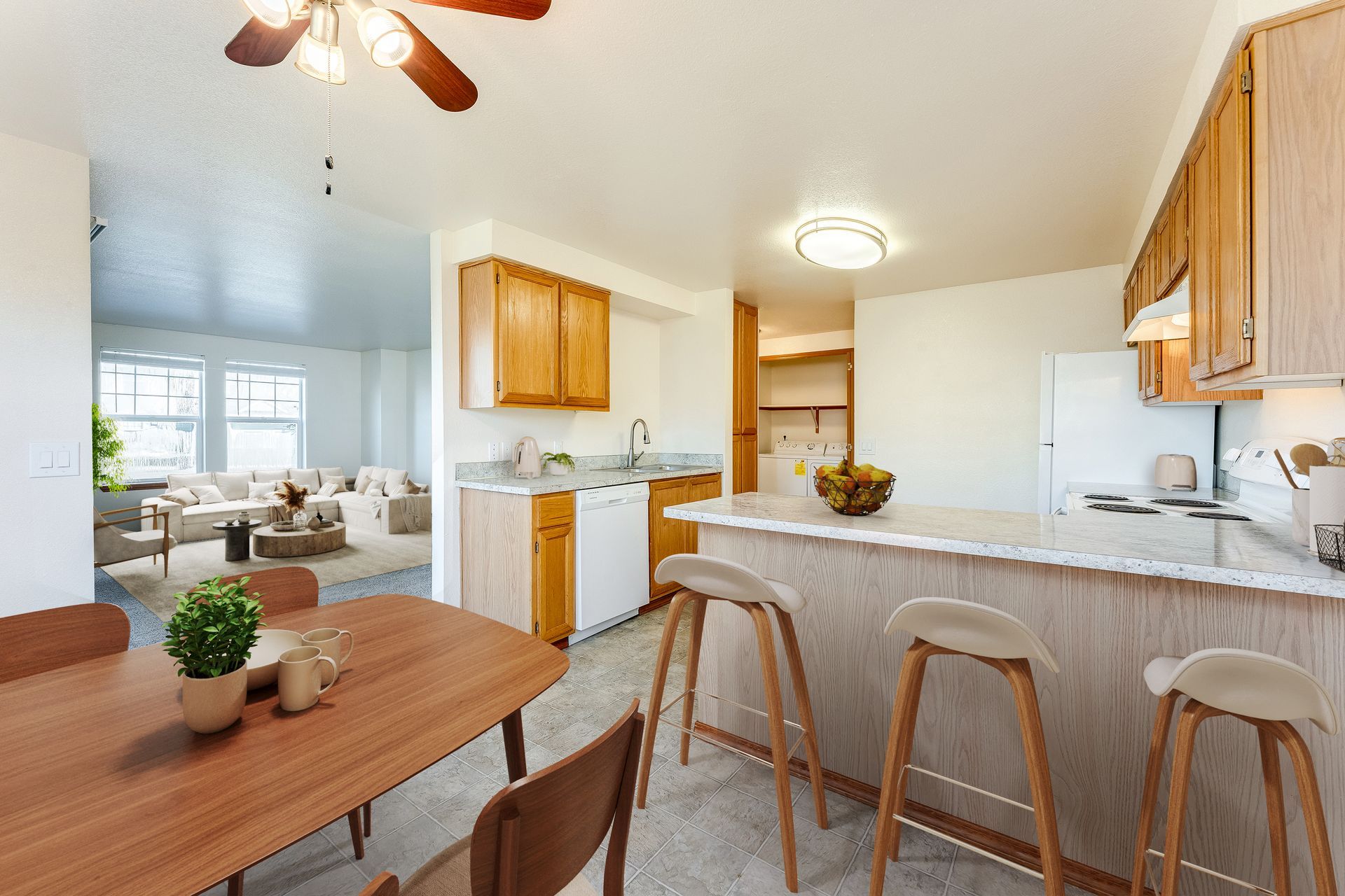 Dining room with view of kitchen over breakfast bar and living room in the background.