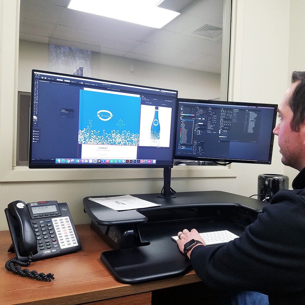 Artist working on design computer on shrink sleeve rendering