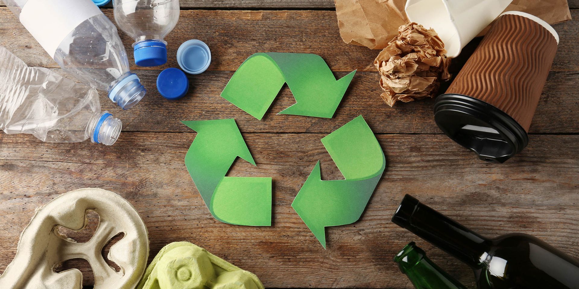 RECYCLING SYMBOL WITH PRODUCTS AROUND