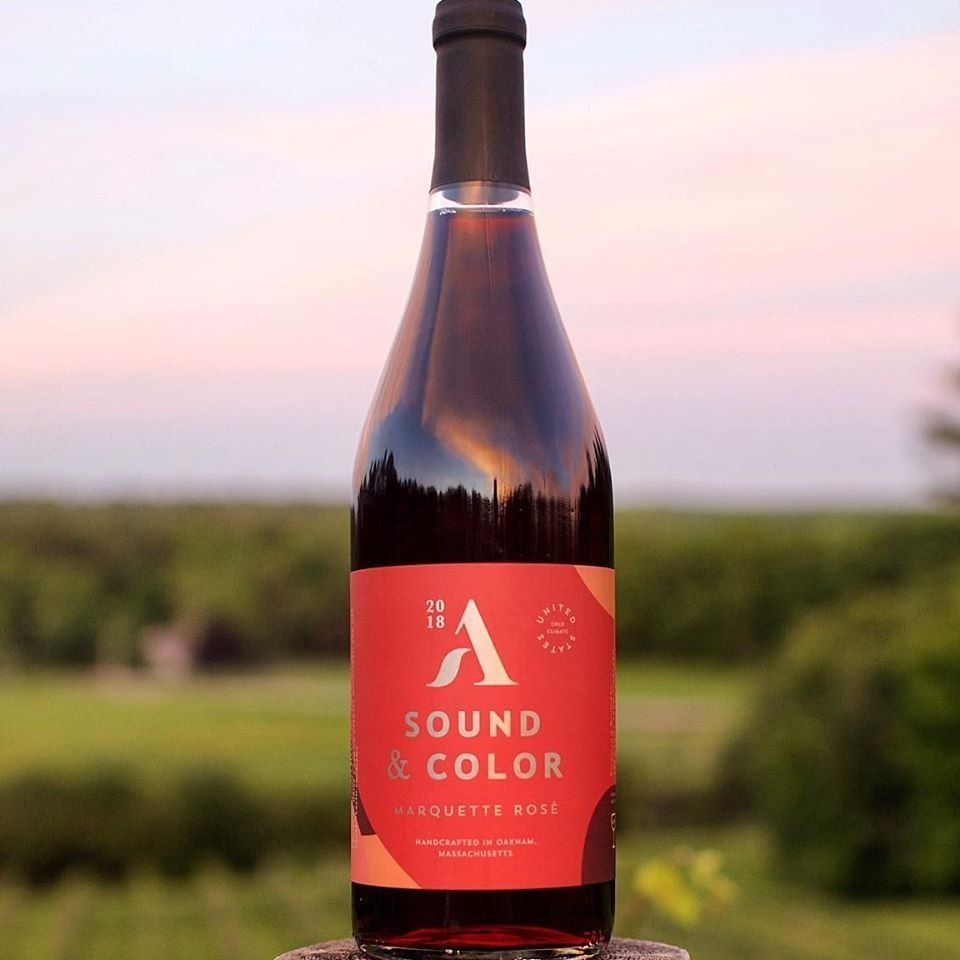 Bottle of Agronomy Farm's Sound & Color Rose with exspansive fields in background