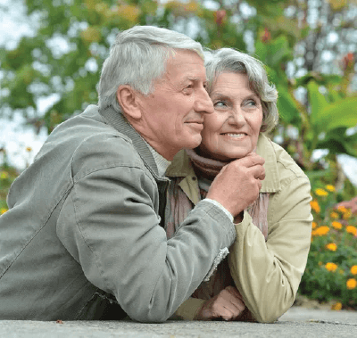 A man and a woman are sitting next to each other and smiling for the camera.