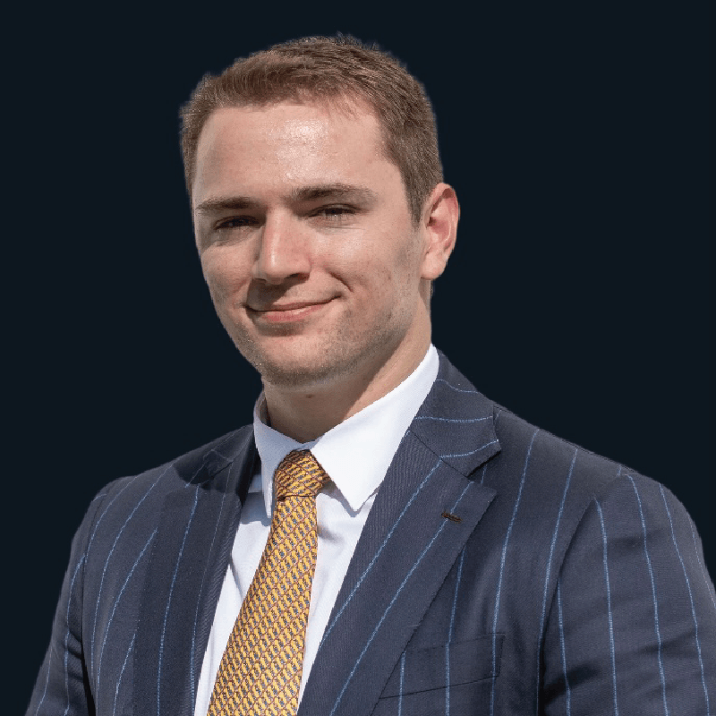 A man in a suit and tie is smiling for the camera.
