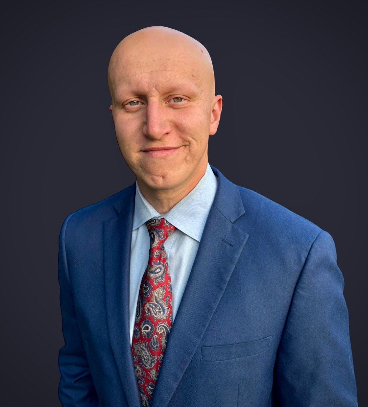 A man in a suit and tie is smiling for the camera.