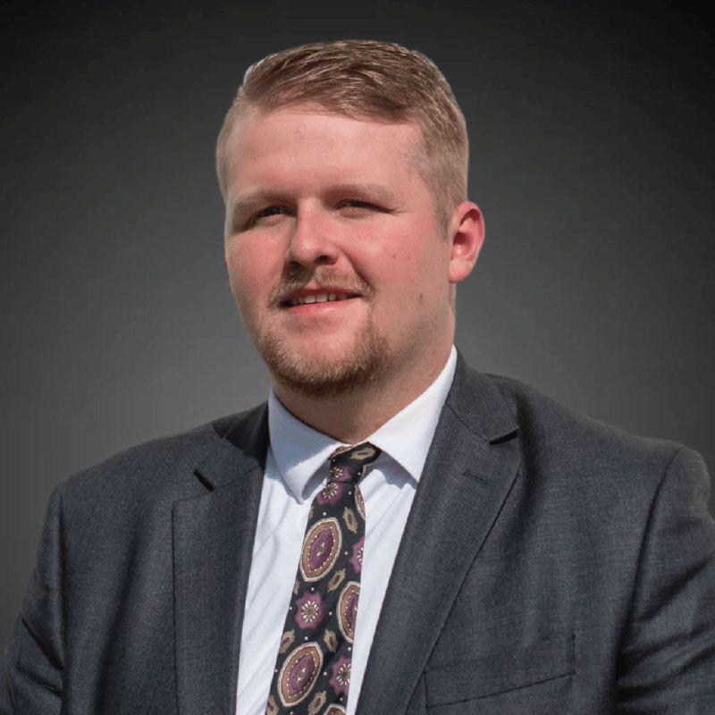 A man in a suit and tie is smiling for the camera