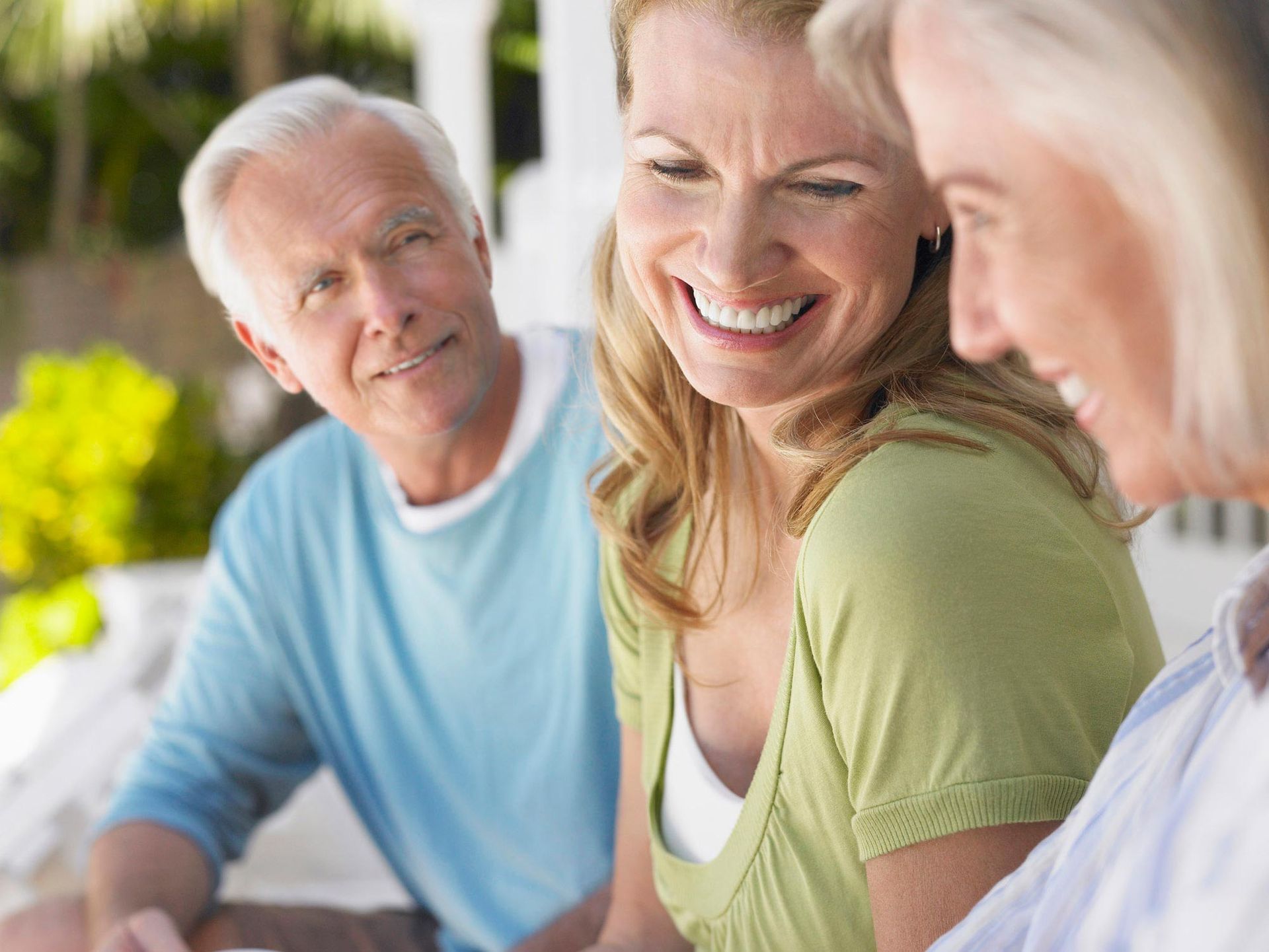 A group of people are sitting around a table and smiling.