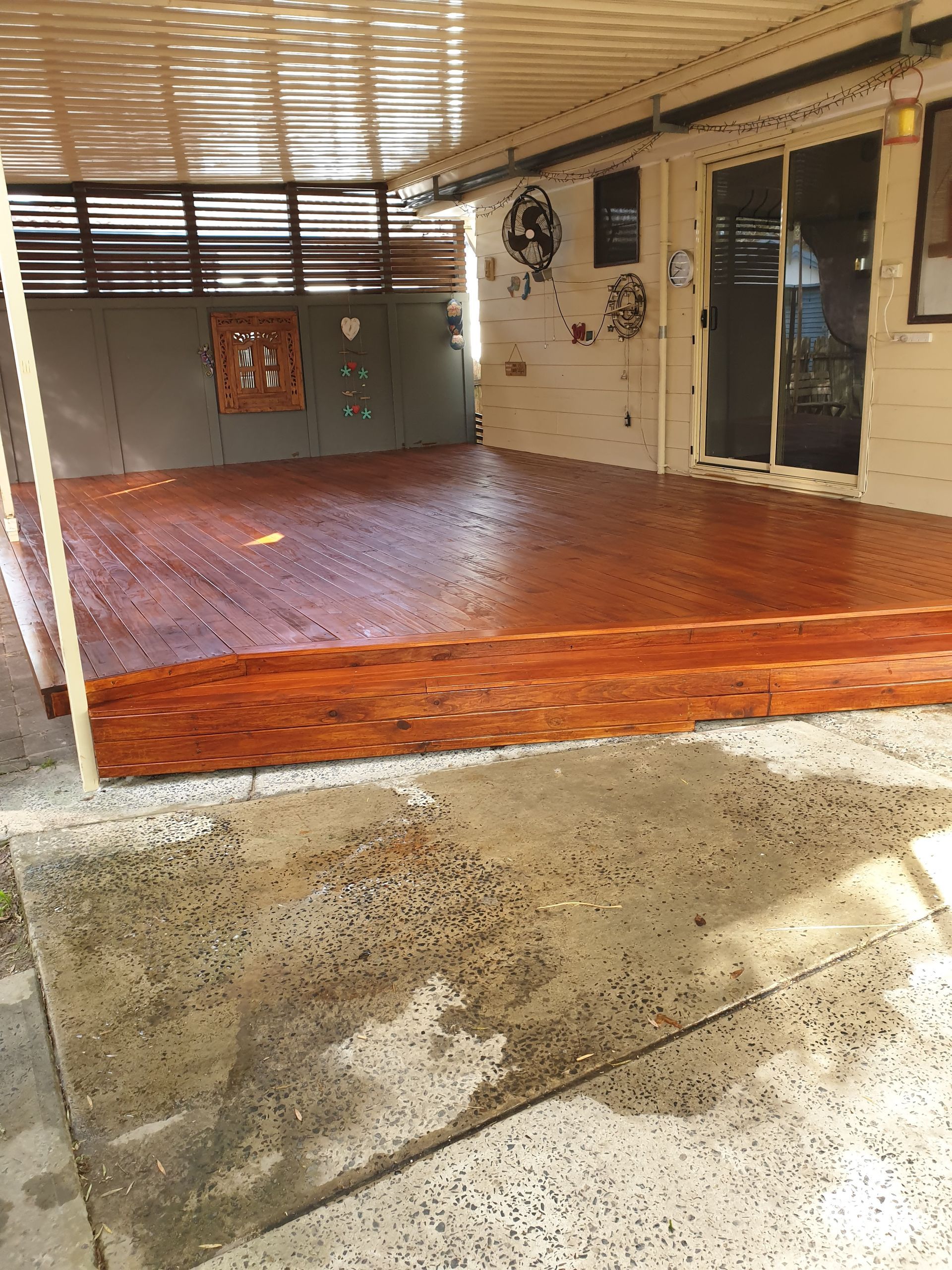 Wooden deck with step down to concrete patio, under a covered patio. — Totally Building and Maintenance in Kincumber, NSW