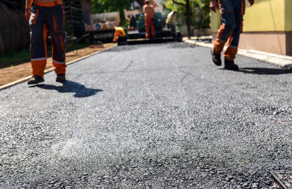 Road Workers Paving a Street With Asphalt — Totally Building and Maintenance in Kincumber, NSW