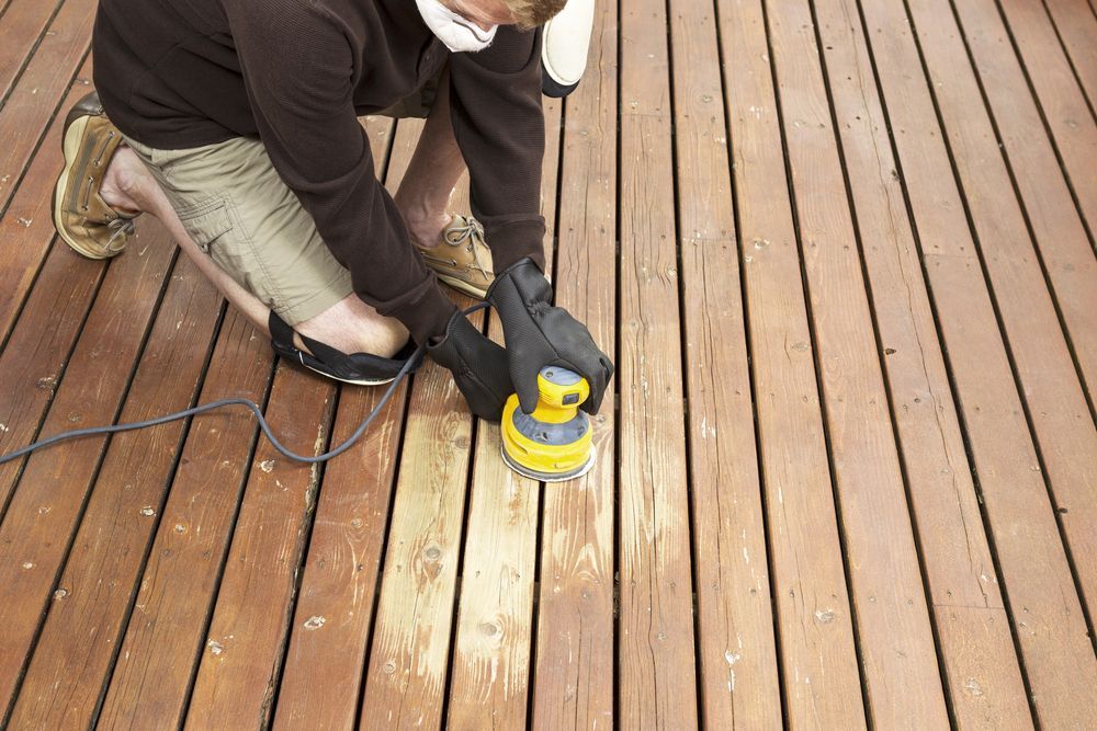 Person Sanding a Wooden Deck With an Electric Sander — Totally Building and Maintenance in Gosford, NSW