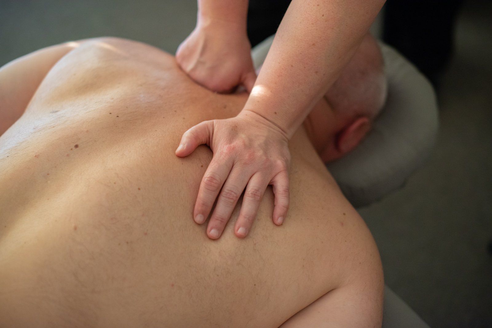 A man is getting a massage from a woman.