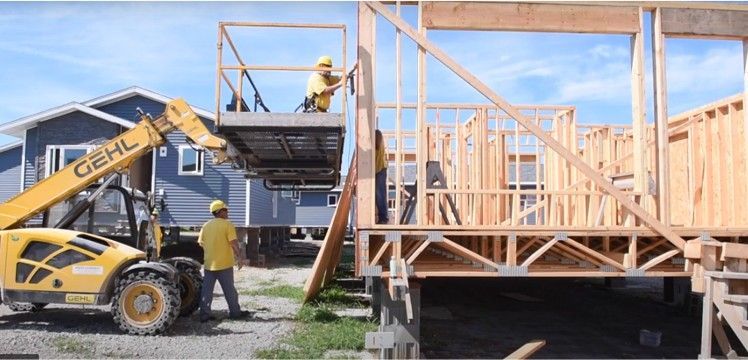 Two men framing an HFI house at the building site in Newton.