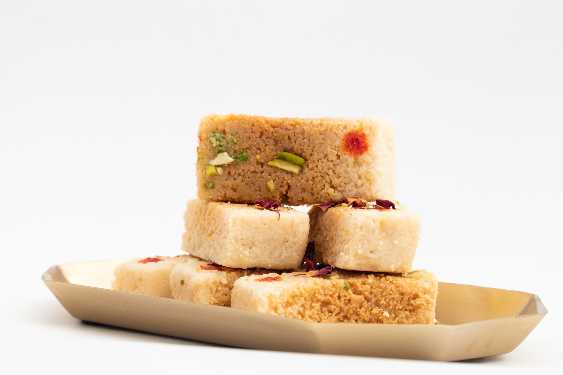 Un vassoio di legno pieno di pezzi di cibo su uno sfondo bianco.