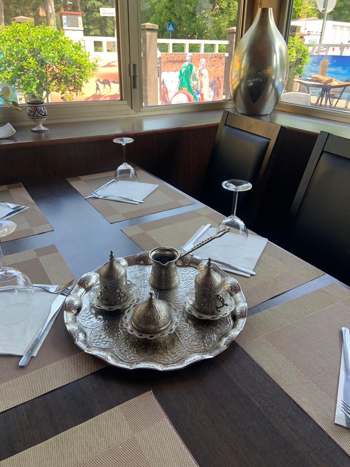 Un tavolo apparecchiato per un pasto con sopra un vassoio di tazze da caffè.