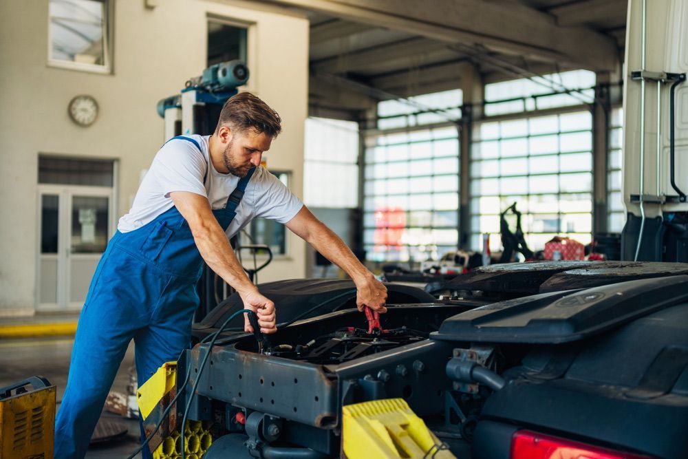 Man is Working on a Truck in a Garage — Oaks Automotive Pty Ltd in Oak Flats, NSW
