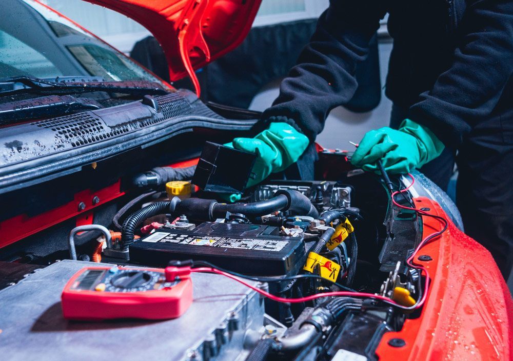 Man is Working on the Engine of a Red Car — Oaks Automotive Pty Ltd in Oak Flats, NSW