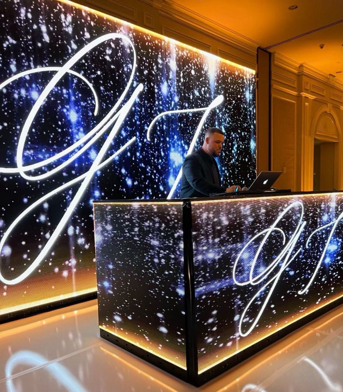 A man sitting at a desk with the letter g on it
