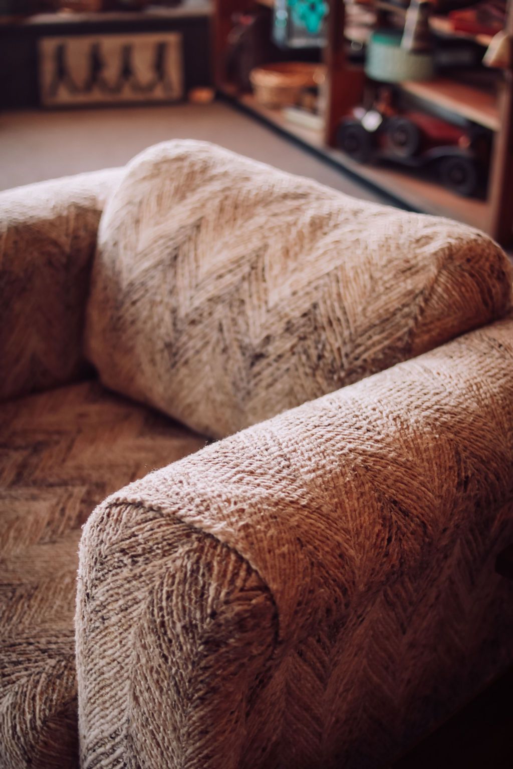 Close-up of a brown, patterned armchair in an indoor setting.