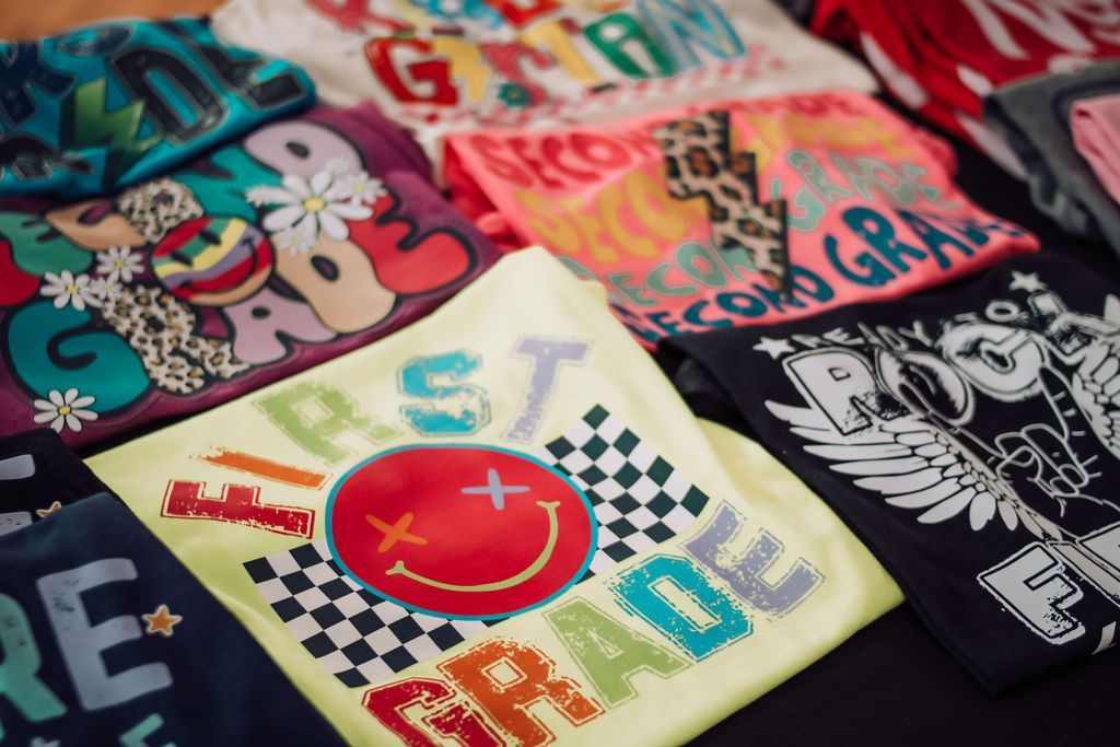 Colorful grade level t-shirts, including 