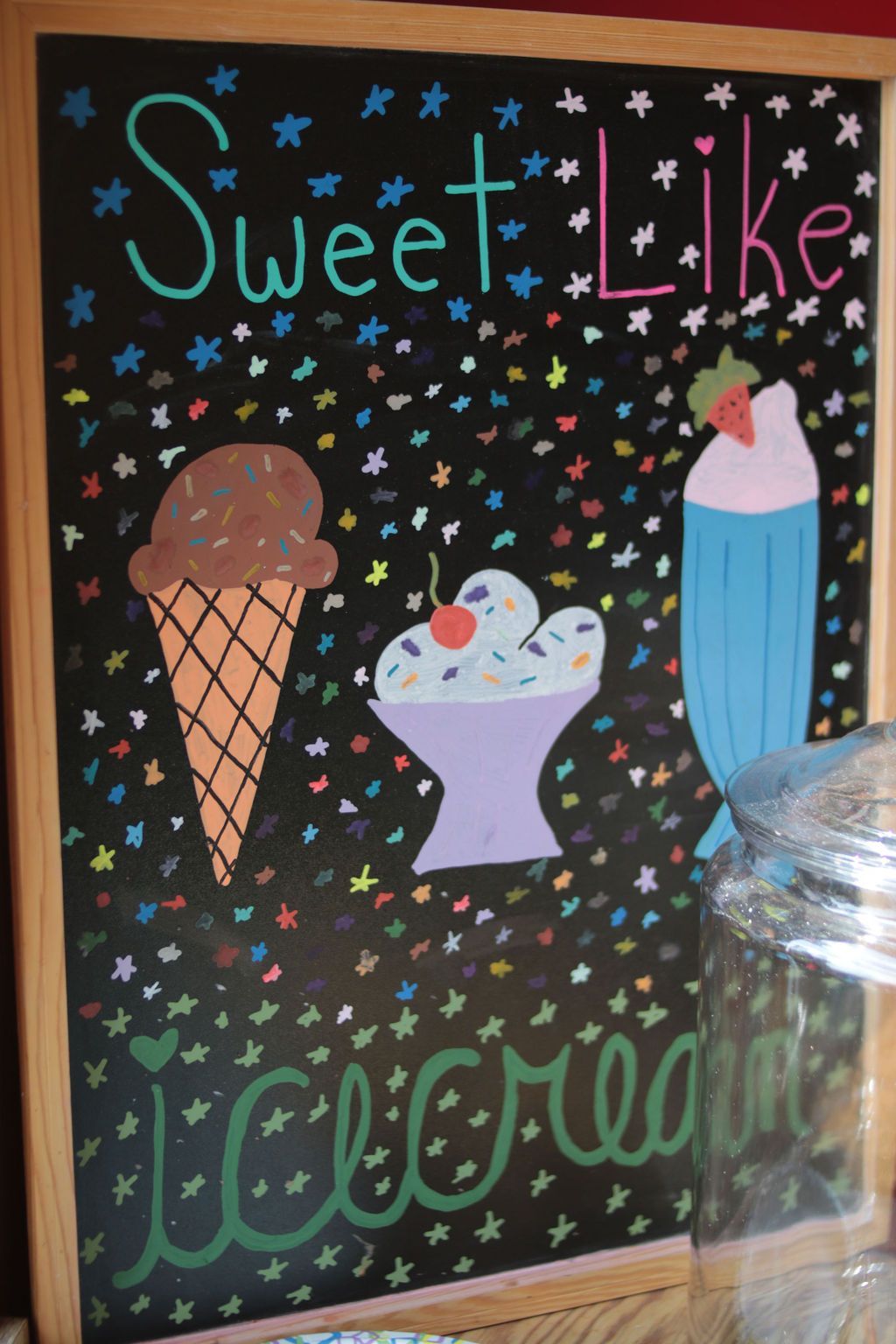 Chalkboard sign with ice cream illustrations. Text reads: 