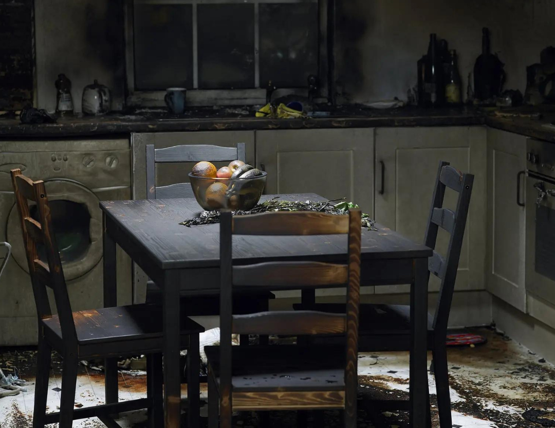A kitchen and dining room with smoke damage.