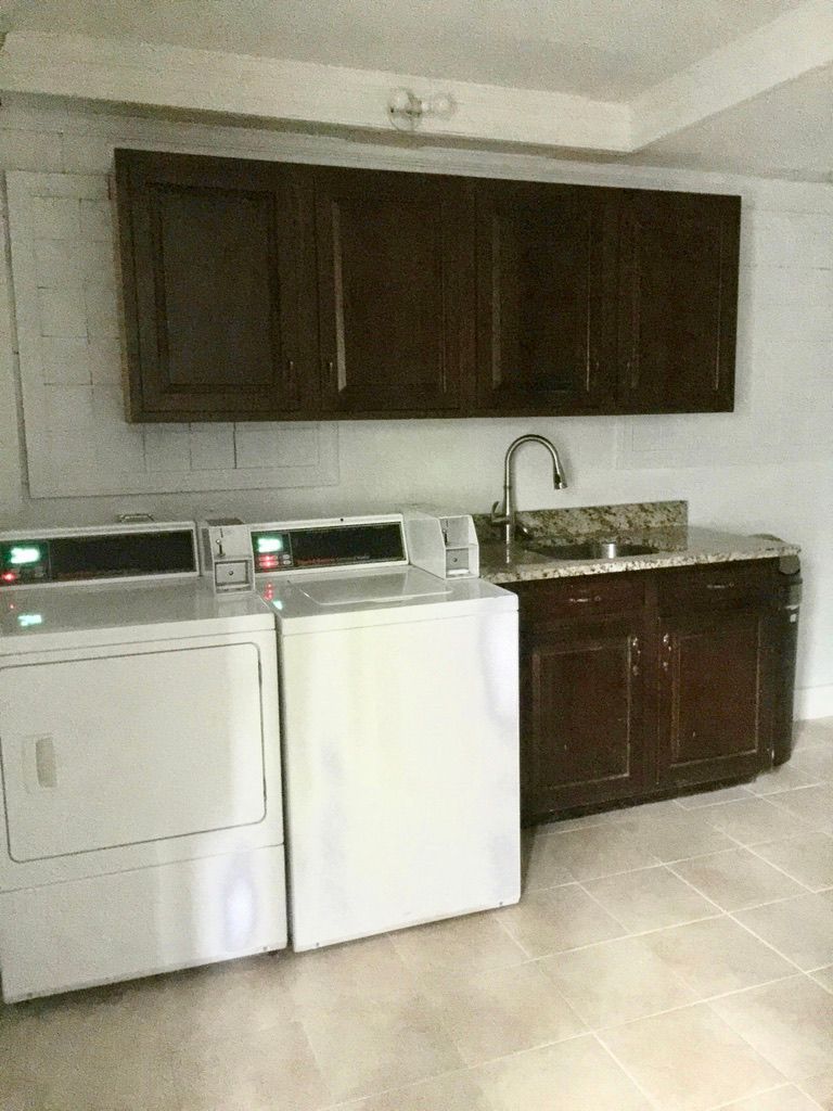 A laundry room with a washer and dryer and a sink.