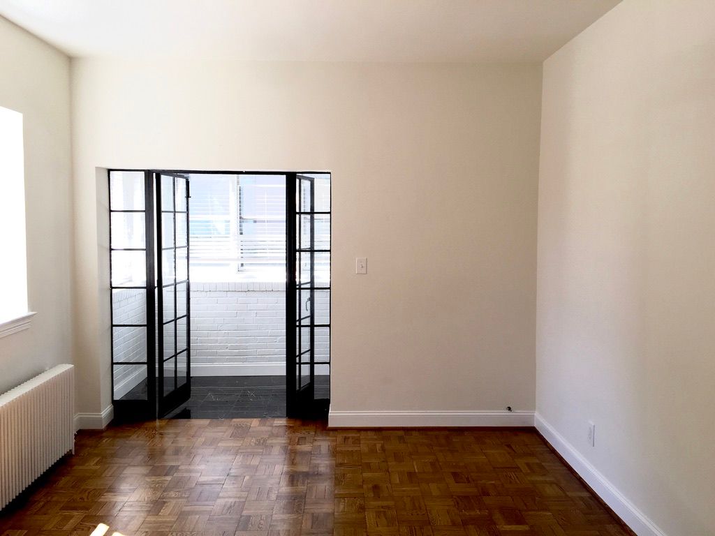 An empty room with wooden floors and white walls